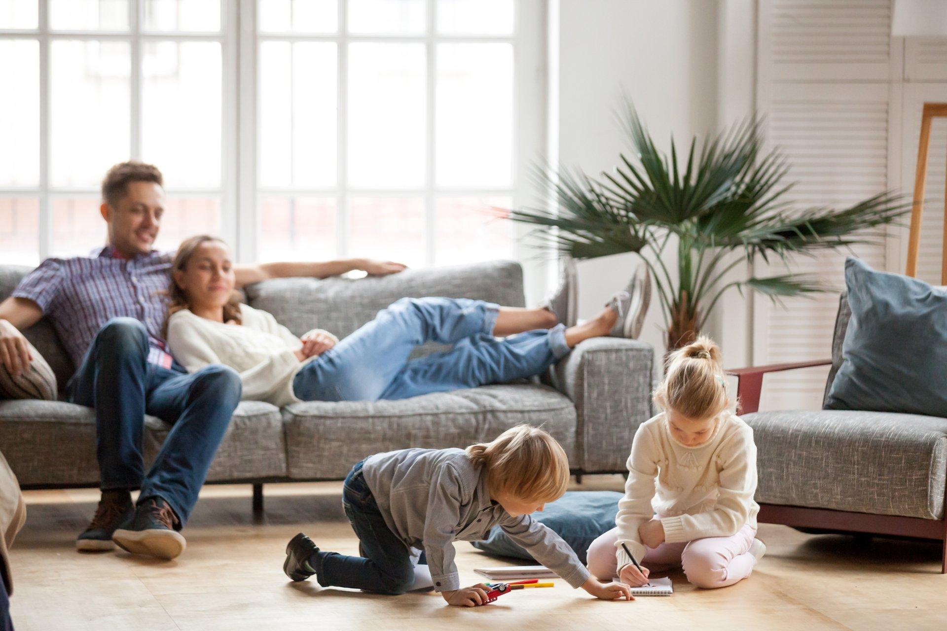 Children siblings playing drawing together while parents relaxin