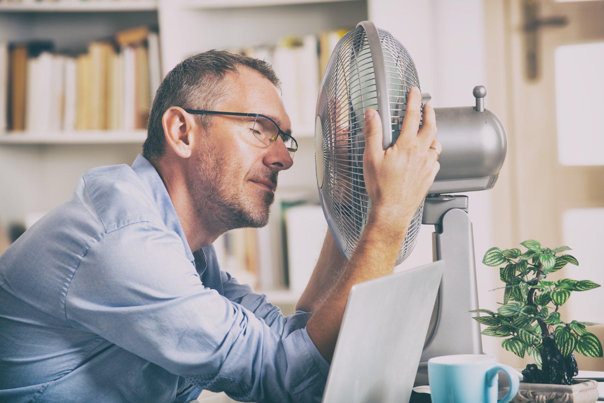 Man suffers from heat in the office or at home