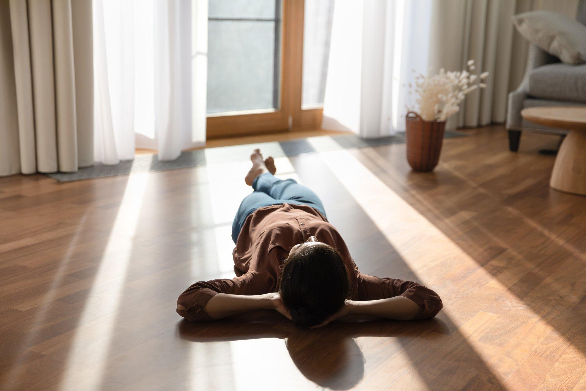 Happy young indian woman lying on warm floor.