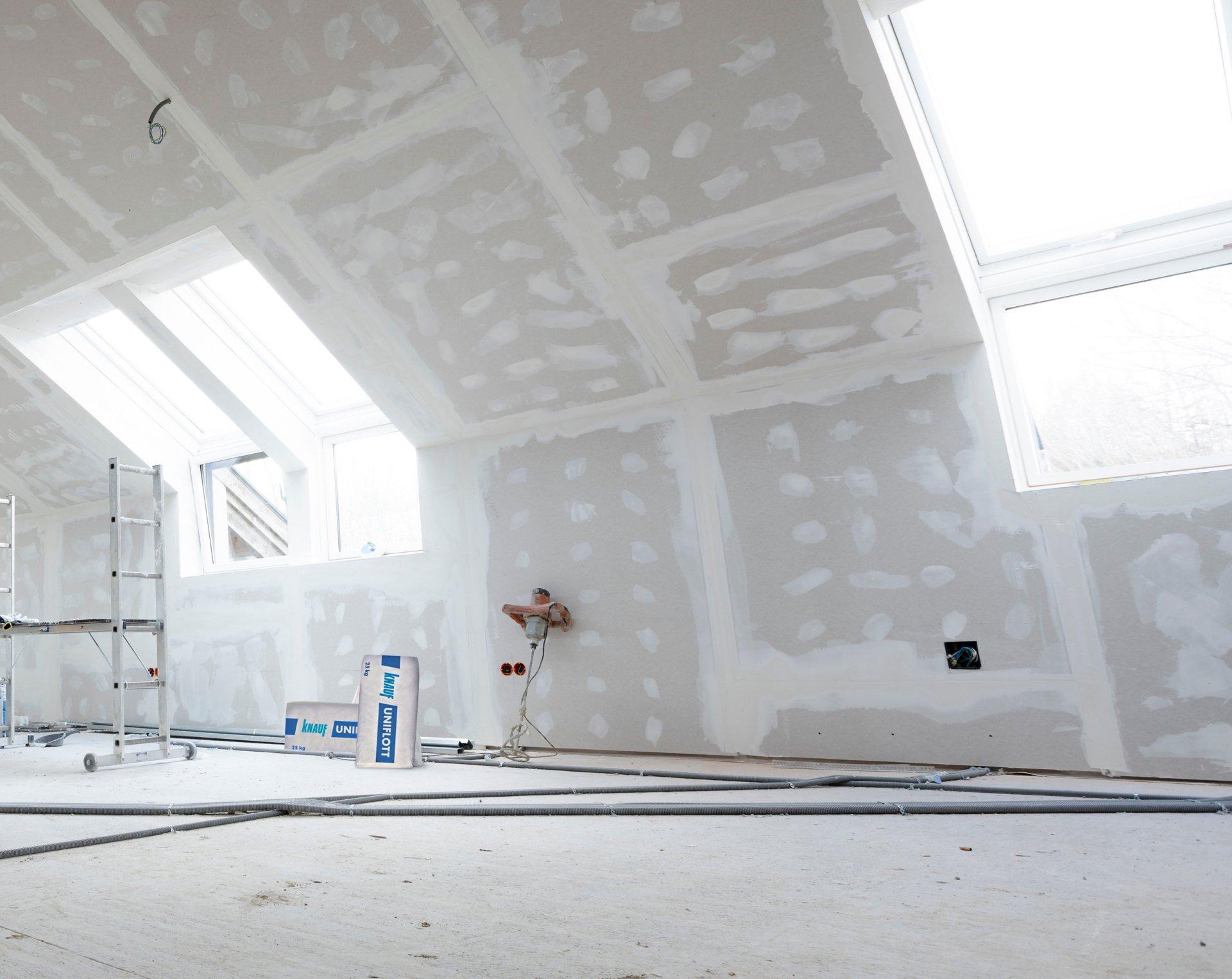 Attic finishing construction site in the phase drywall spackling and plastering before screeding