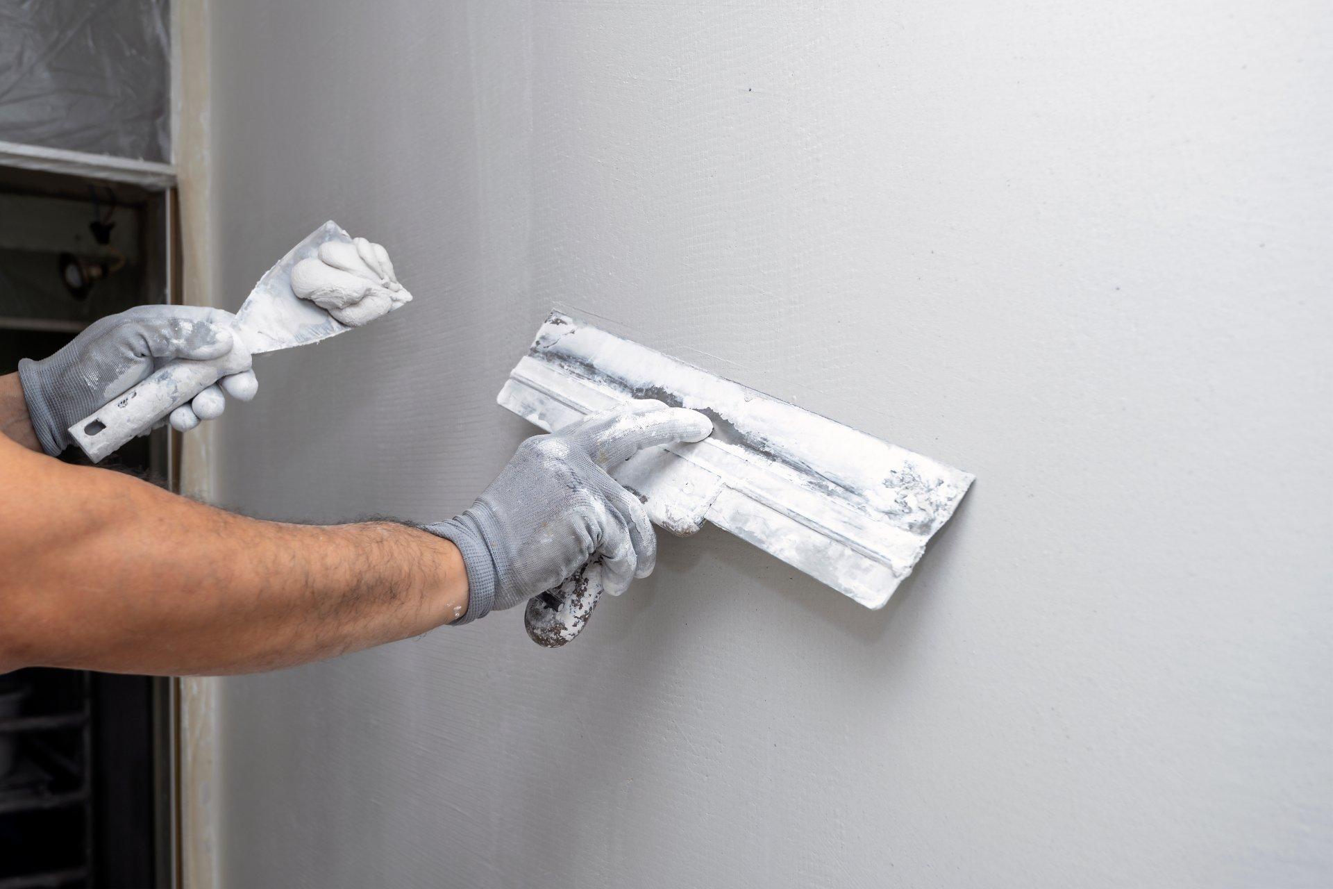 Plasterer applies plaster on the wall during repair and restoration work