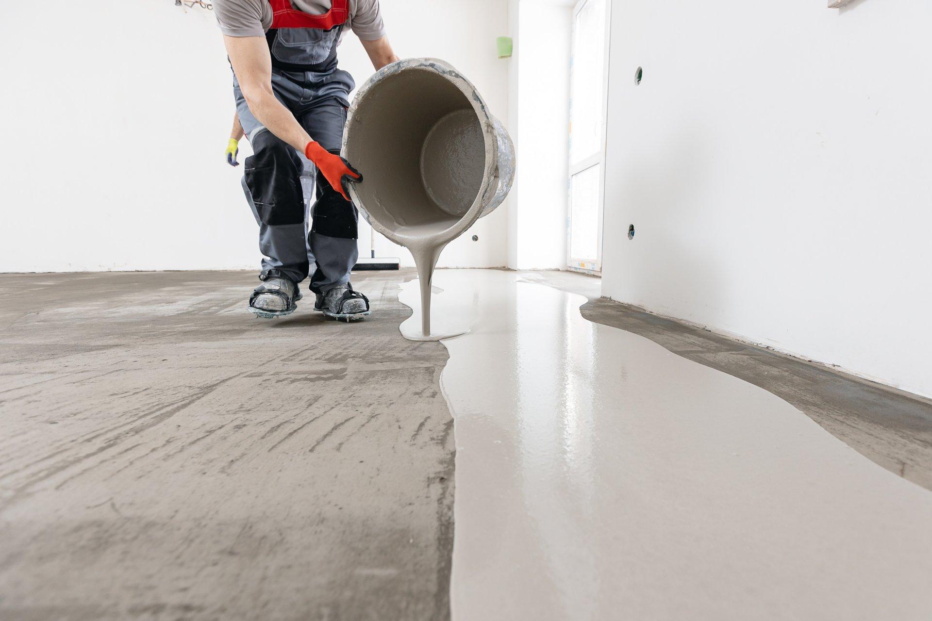 Worker use screed concrete epoxy for level. Leveling with mixture of cement for floors