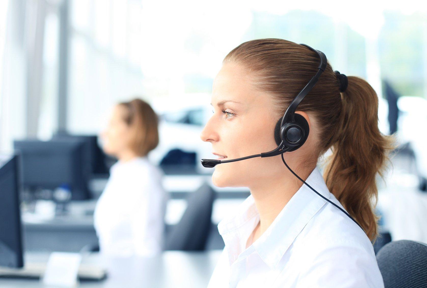 Beautiful young female call center operator with headset